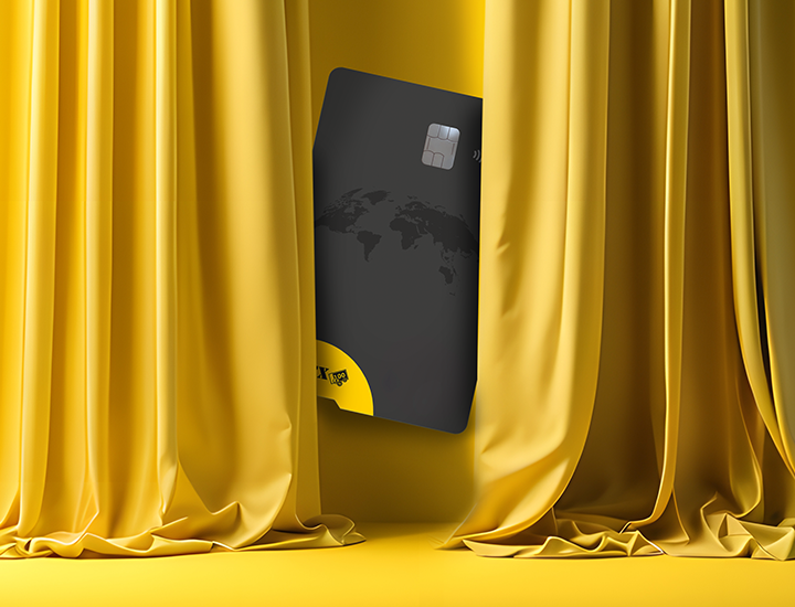 A credit card between two yellow and golden curtains