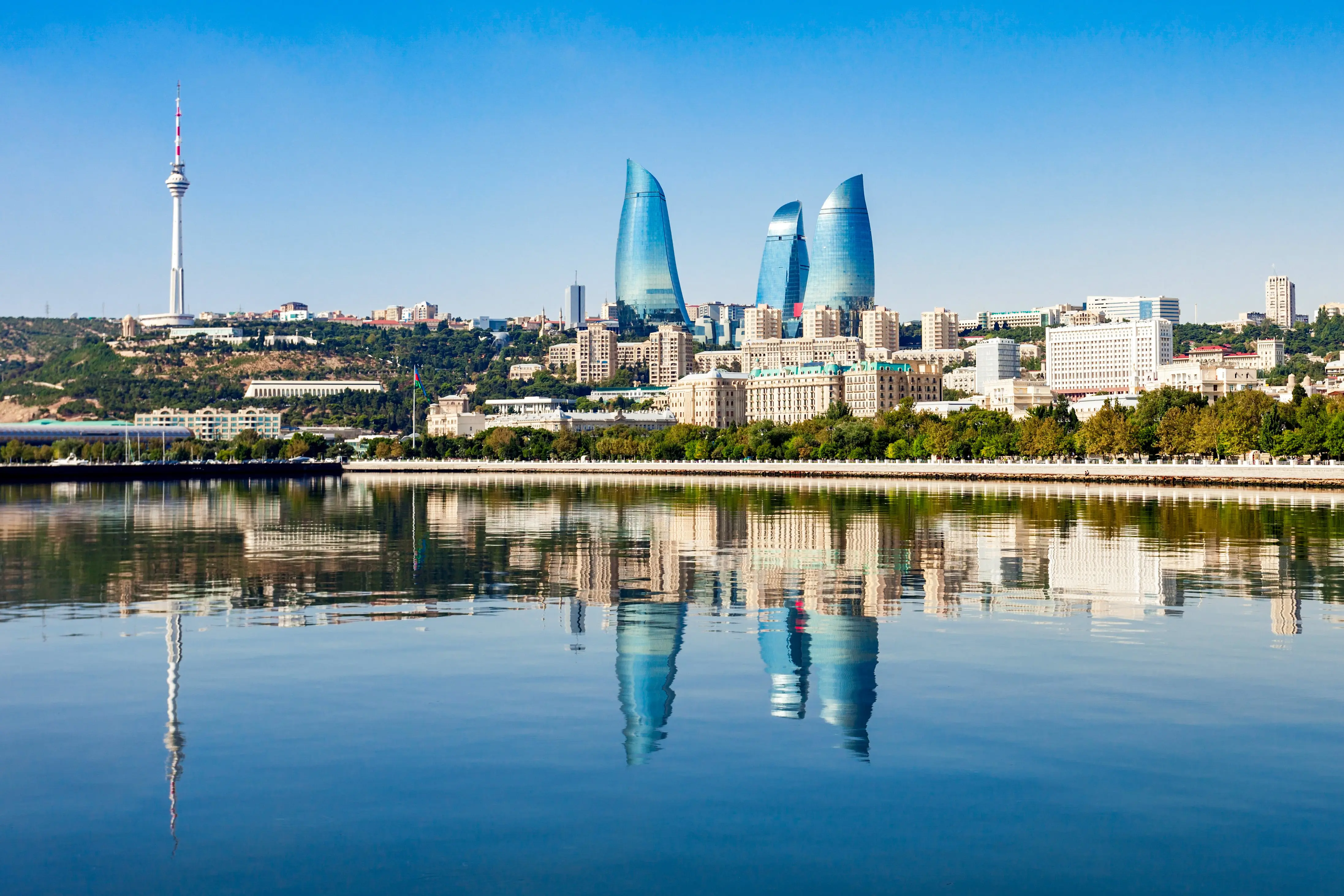 Resa till Baku - Hav möter Baku-stad med skyskrapor som når en blå himmel med gröna träd runtomkring sig