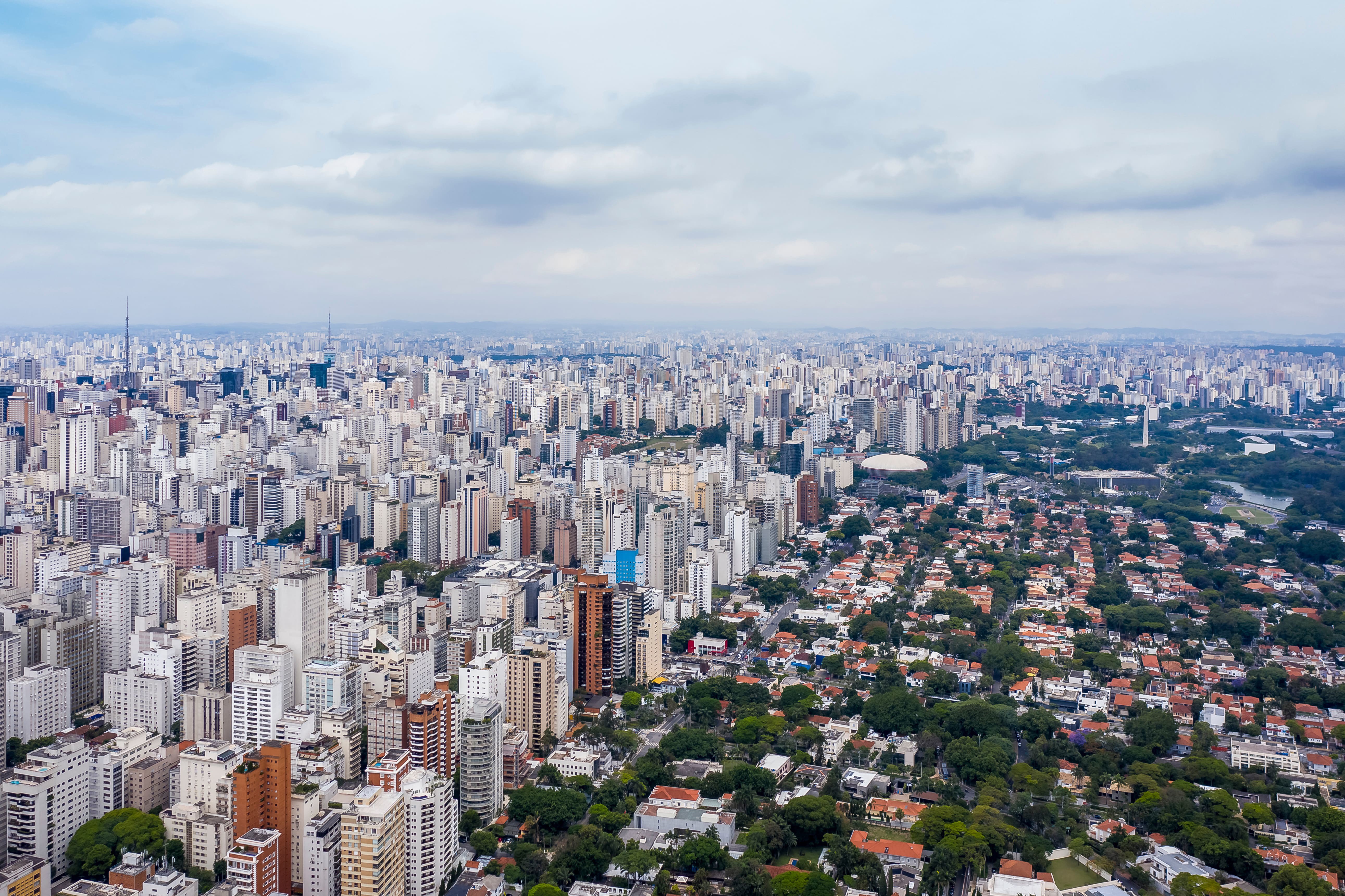 Panorama vy över São Paulo-stad, byggnader möter massa grönska och parker med en molnig himmel