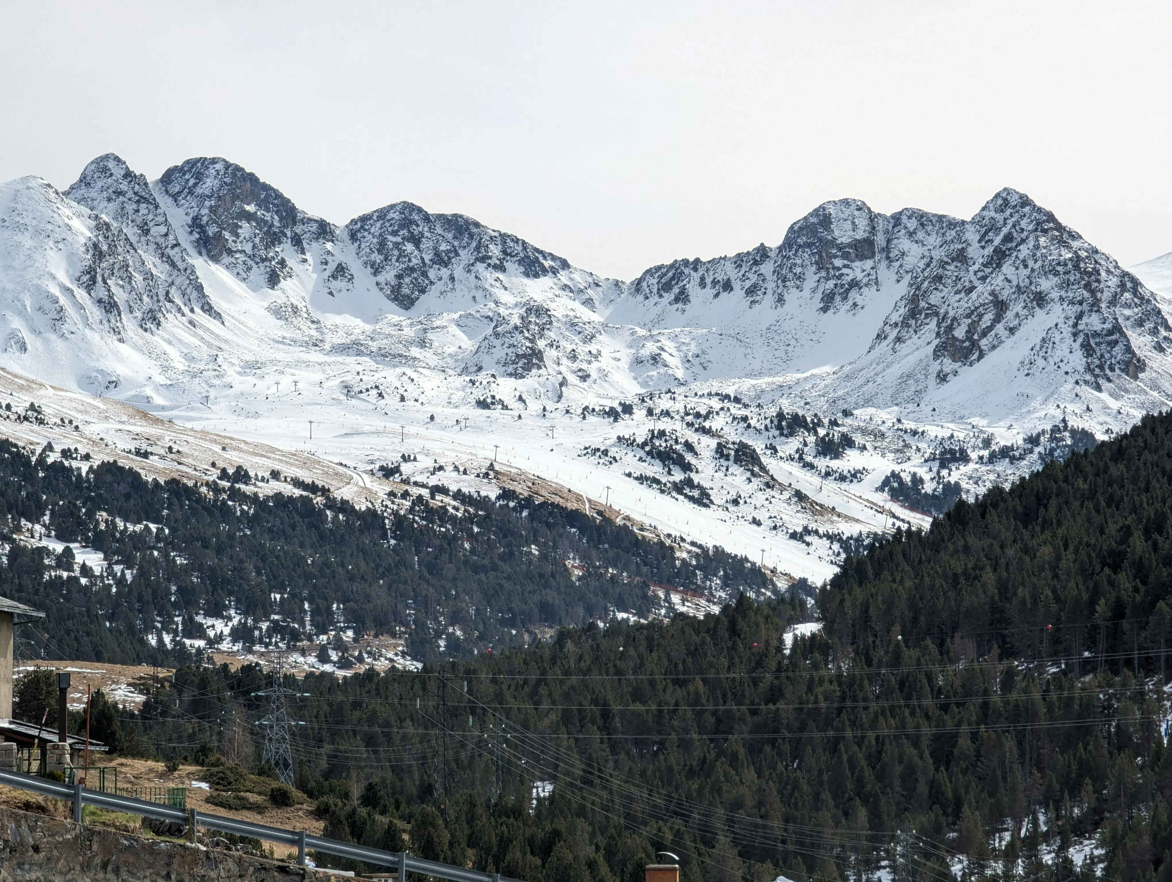 Travel to Grandvalira - View of mighty snow-capped mountains with a green valley between them in Andorra