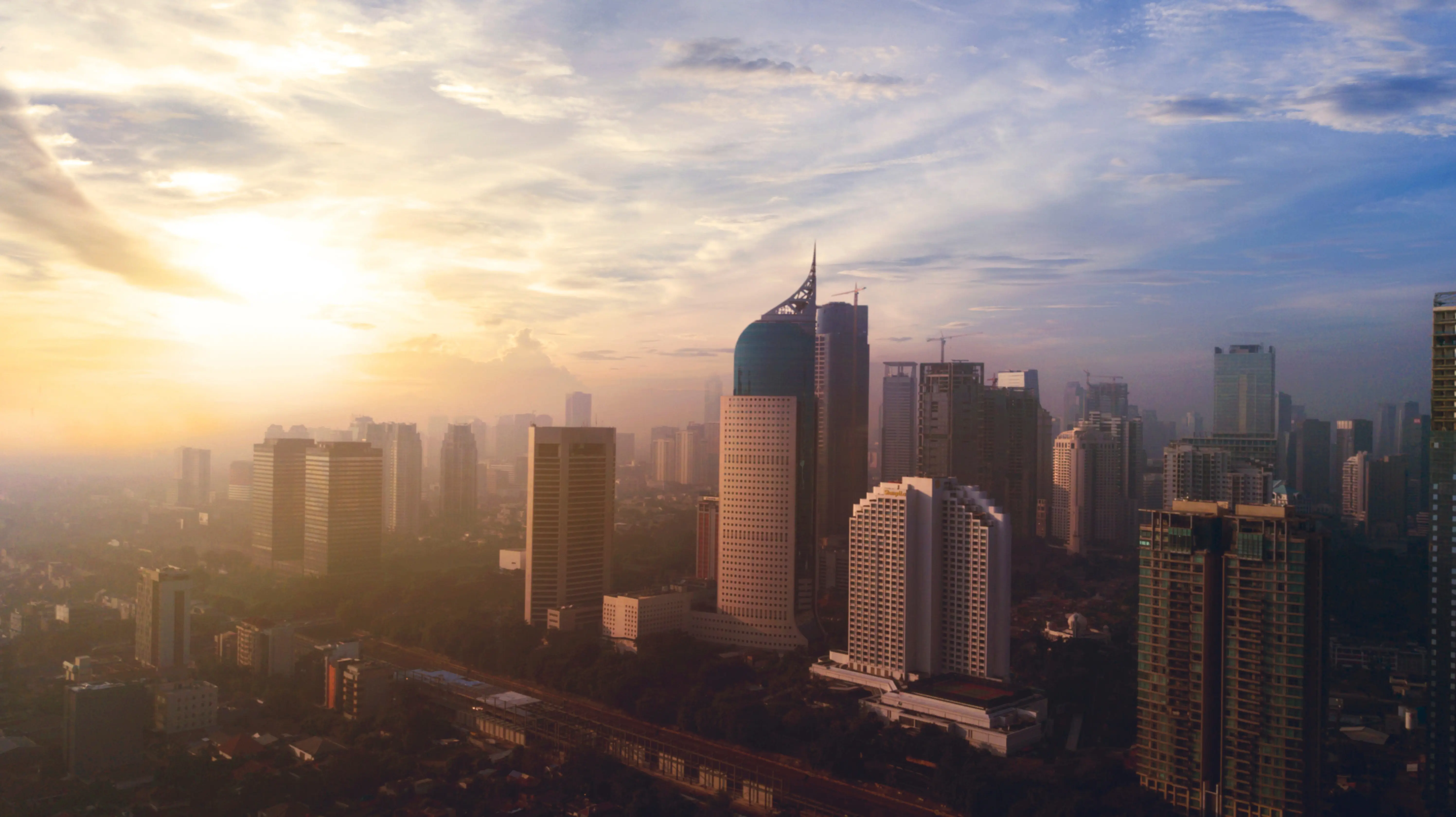 Resa till Jakarta - Soluppgång över skyline i Jakarta men skyskrapor som möter en blå himmel