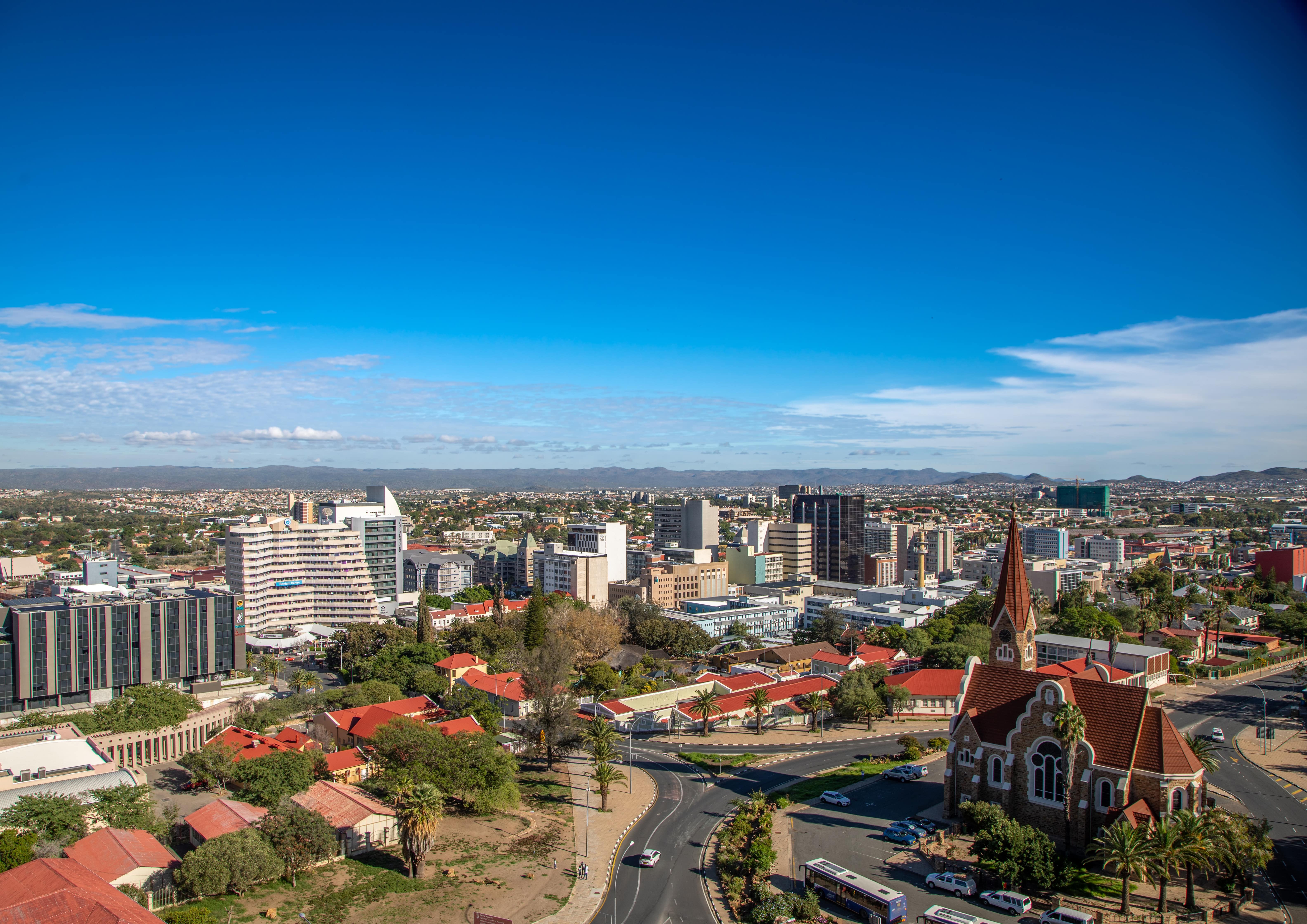 Matkusta Windhoekiin - Panoraamanäkymä Windhoekin kaupunkiin Namibiassa, jossa on rakennuksia ja vehreyttä