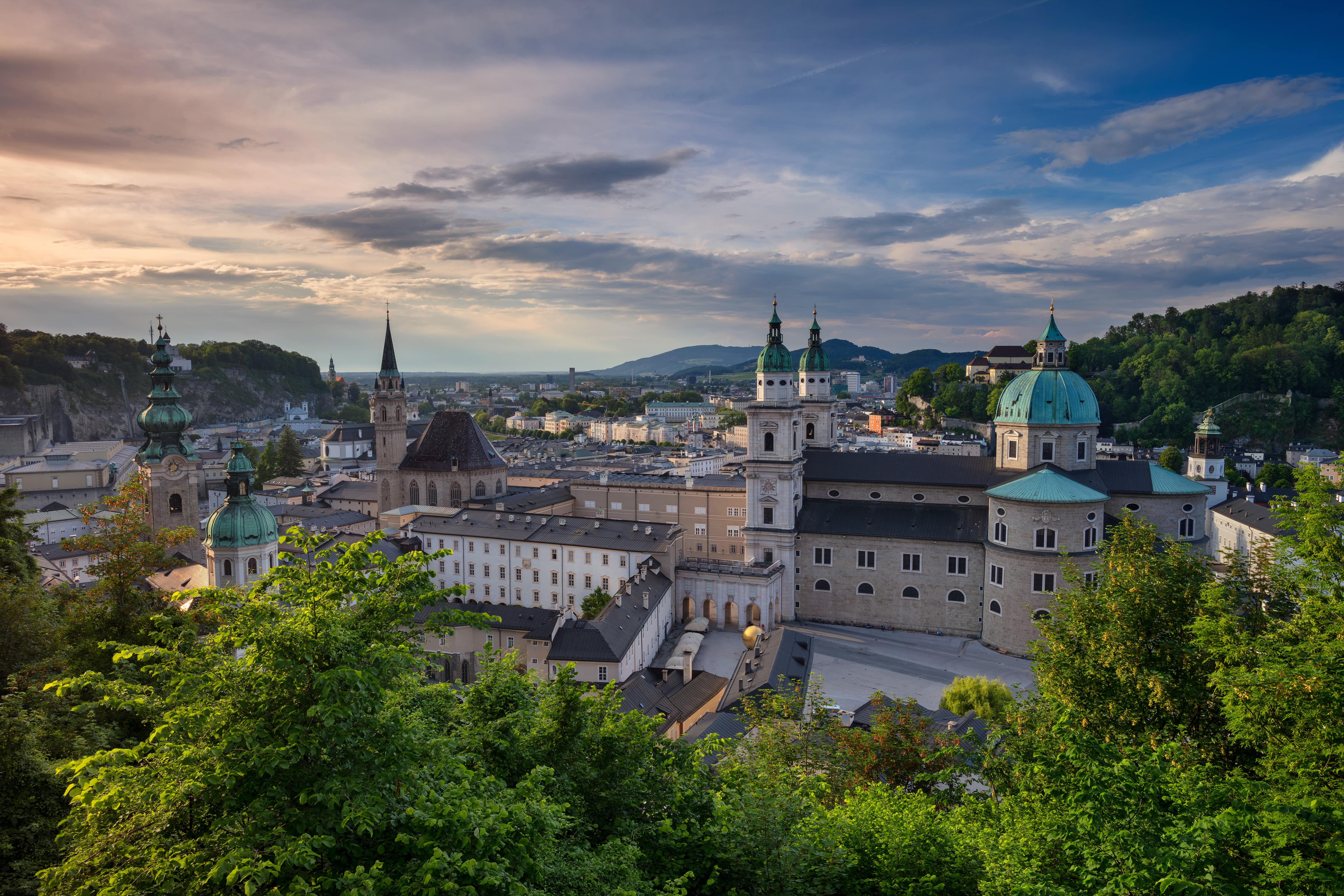 Resa till Salzburg - Solnedgång över Salzburgs gamla stan med vackra äldre byggnader och grönska omkring sig