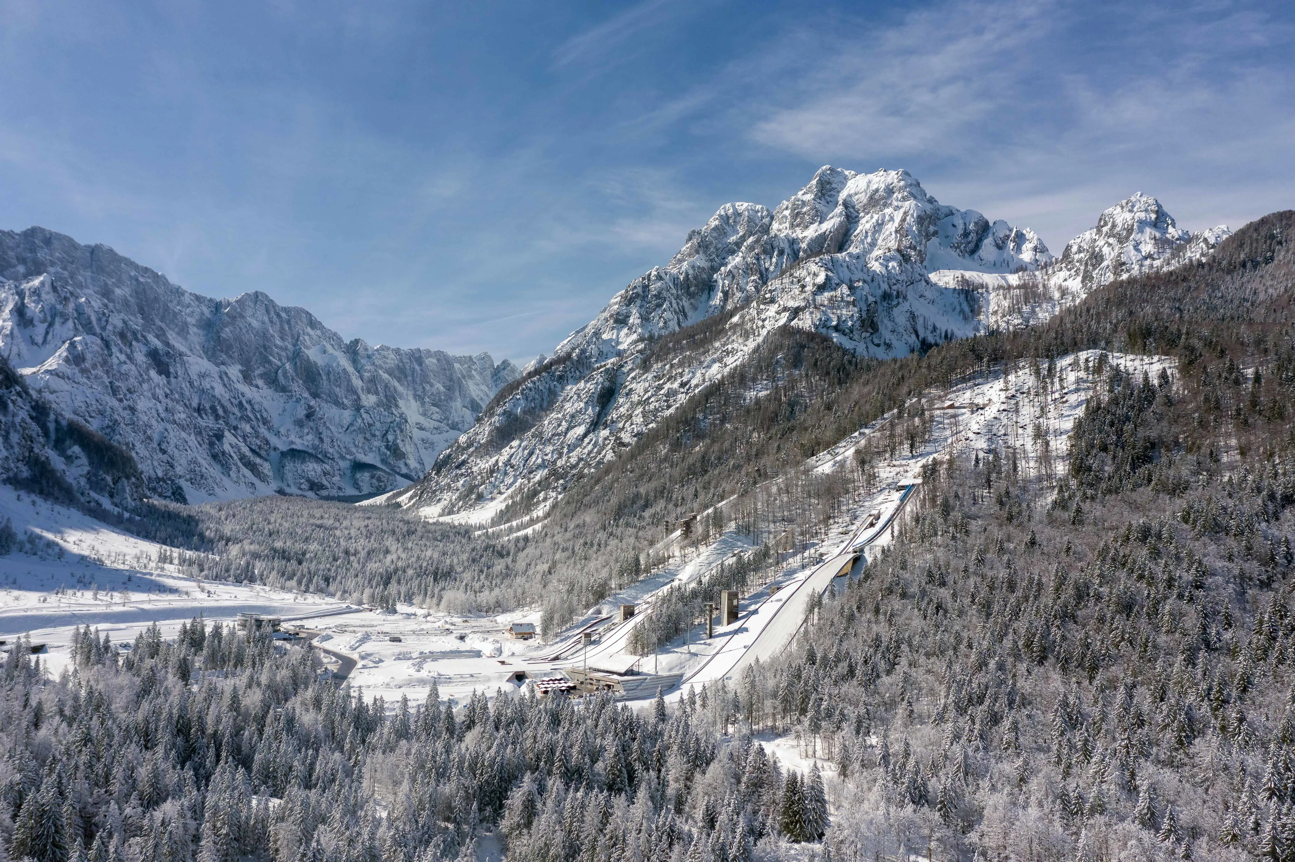 Beautiful natural landscape in Kranjska Gora, Slovenia with snow-capped mountains and ski slope down in a ski resort