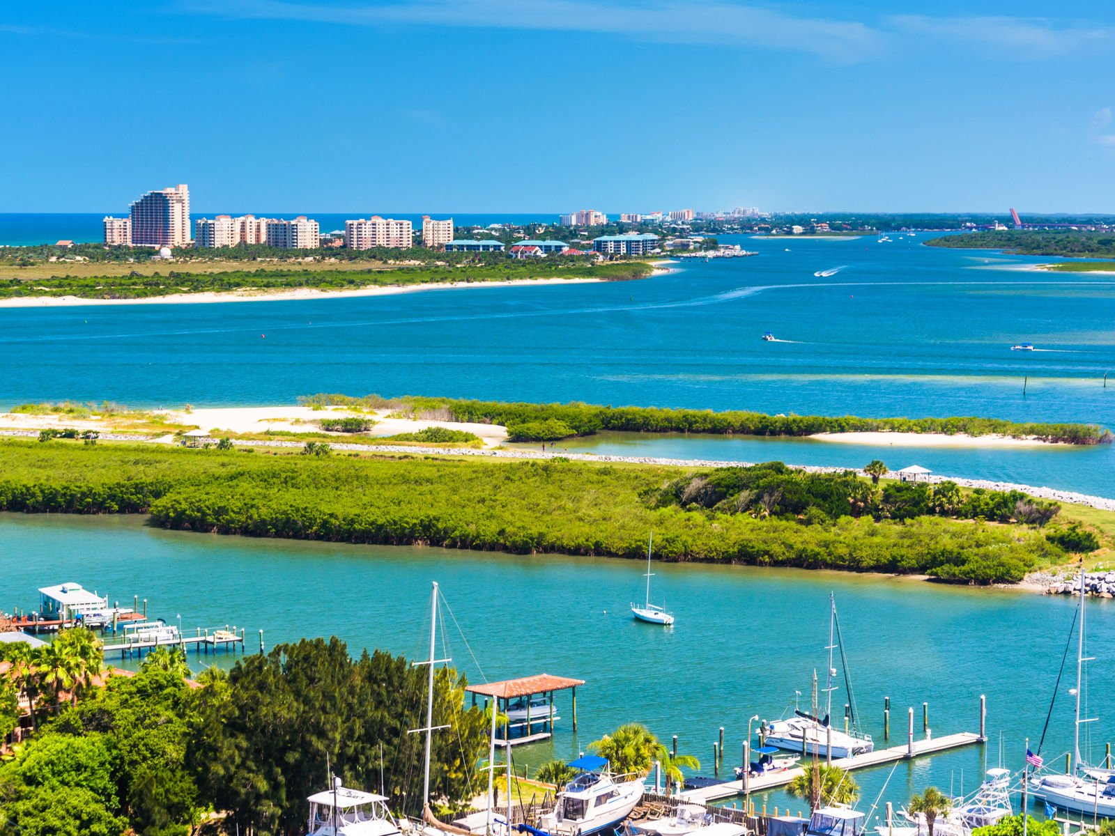 sininen meri, taustalla vehreys, satama ja kaupunki Floridassa
