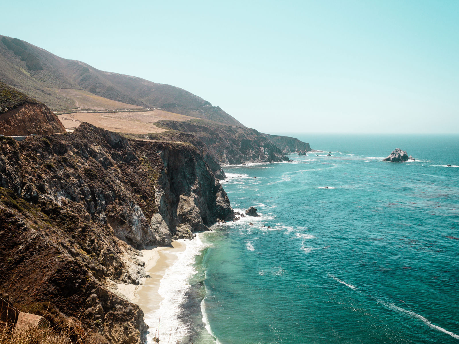 kust i kalifornien med hav som kommer in vid klipper och strand